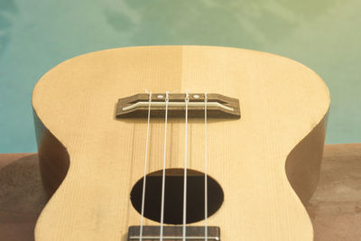 Close-up of guitar on table at poolside