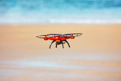 Flying drone with mounted camera on the beach