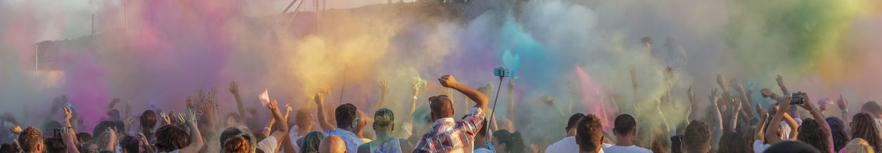 Panoramic view of crowd at music concert against sky