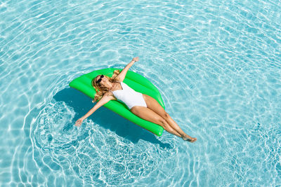 High angle view of man relaxing in swimming pool