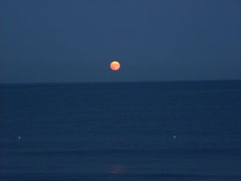 Scenic view of sea against clear sky at night