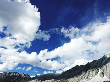 Low angle view of snowcapped mountains against sky