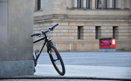 Bicycle parked on street against building