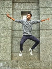 Portrait of smiling young man jumping outdoors