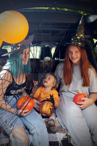 Portrait of happy girl sitting on table during halloween