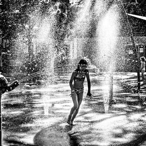 Full length of man splashing water fountain