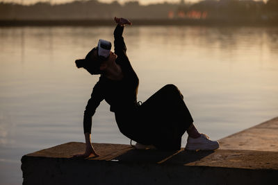 Side view of man photographing while standing by lake