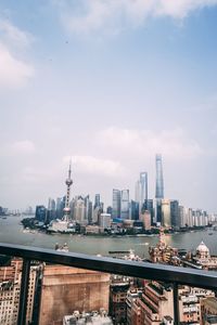 Modern buildings in city against cloudy sky