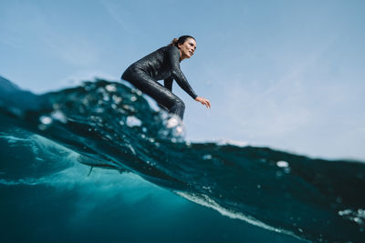 Close up split image of female surfer on a wave