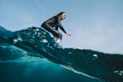 Side view of man in sea against sky