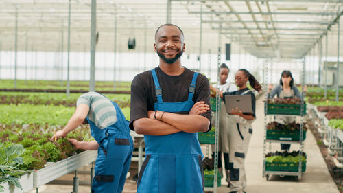 Portrait of young man standing in greenhouse