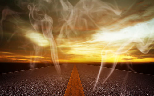 Digital composite image of road against sky during sunset