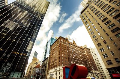 Low angle view of buildings against cloudy sky