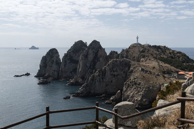 Rock formations by sea against sky