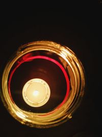 Close-up of illuminated tea light over black background