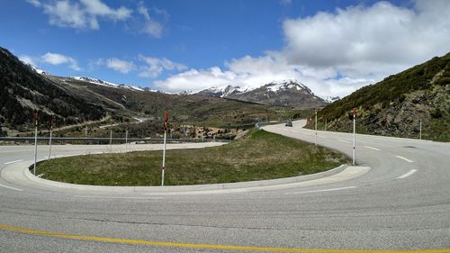 Road by snowcapped mountains against sky