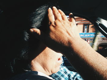 Woman shielding eyes in car