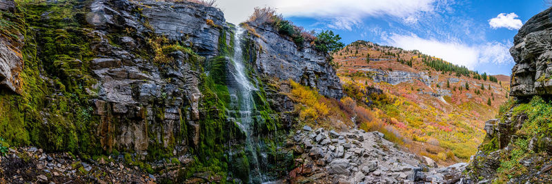 Panoramic view of rock formation amidst trees against sky