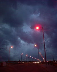 Illuminated street light against sky at night