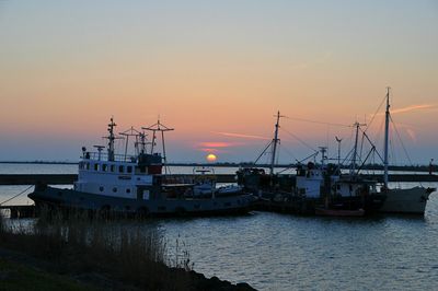 Boats at harbor during sunset