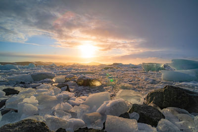 Scenic view of frozen lake against sky during sunset