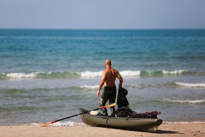 Man on shore at beach against sky