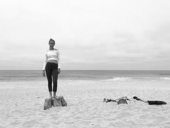 Rear view of man standing on beach against sky
