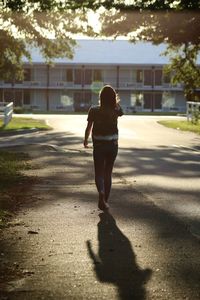Rear view of teenage girl walking on street