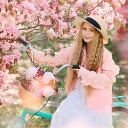 Woman standing by pink flowering plant