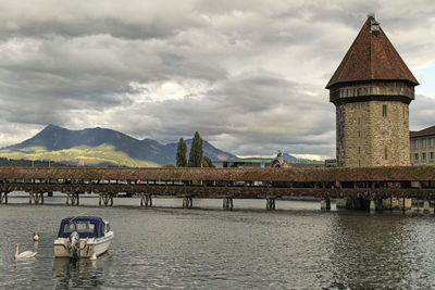 Bridge over river against cloudy sky