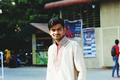 Portrait of young man in kurta standing against built structure