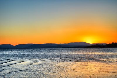 Scenic view of sea against clear sky during sunset