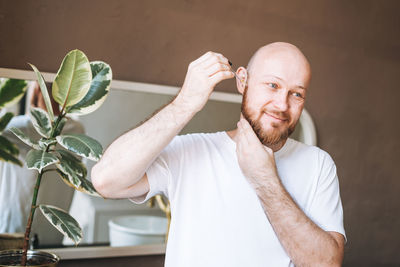 Portrait of senior man holding plant