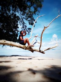 Full length of shirtless man on beach against sky