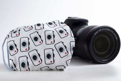 Close-up of camera on table against white background