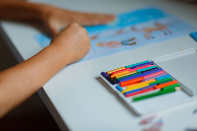 Cropped image of boys hand drawing on paper