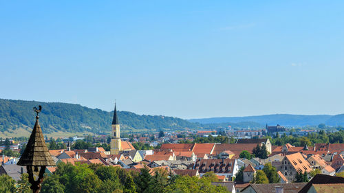 Houses in town against clear blue sky