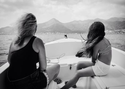 Rear view of friends in boat on sea