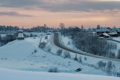 High angle view of snow covered landscape against sky during sunset