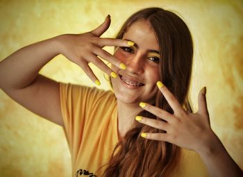 Portrait of girl with yellow nail paint