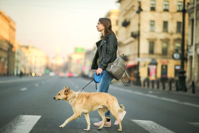 Woman with dog on street in city