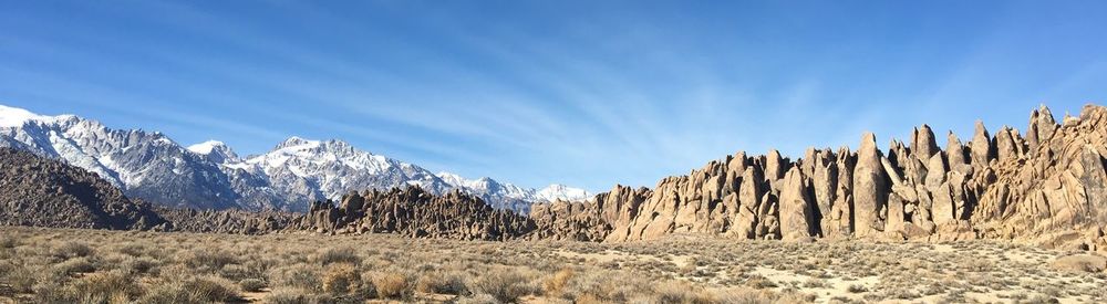 Panoramic view of snowcapped mountains against blue sky