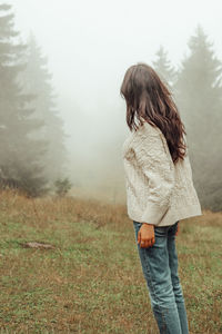 Rear view of woman standing on field