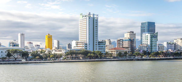 River by buildings against sky in city