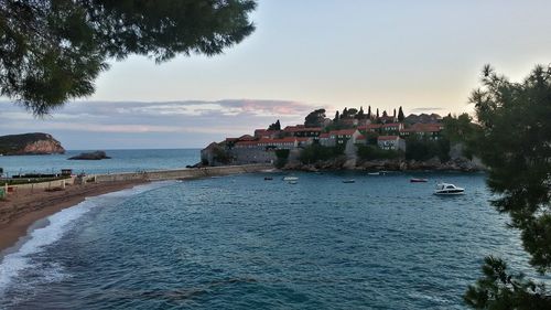 Scenic view of sea by buildings against sky