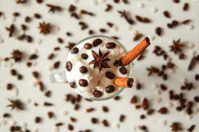 A glass of ice cream with coffee, cinnamon sticks, coffee beans and star of anise. 