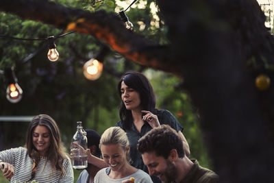 Happy friends enjoying dinner party at yard