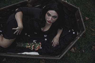 High angle view of young woman sitting on field