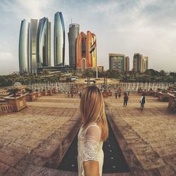 Rear view of woman with buildings in background