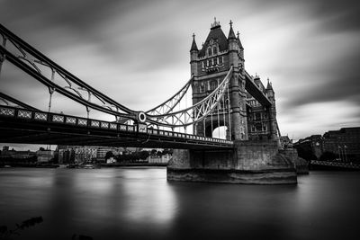 Tower bridge over thames river against sky in city